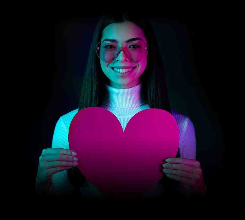 young woman holding a cutout heart